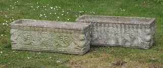 A pair of rectangular well weathered concrete garden trough shaped planters with cast mask and floral decoration 25cm h x 71cm w x 23cm d 