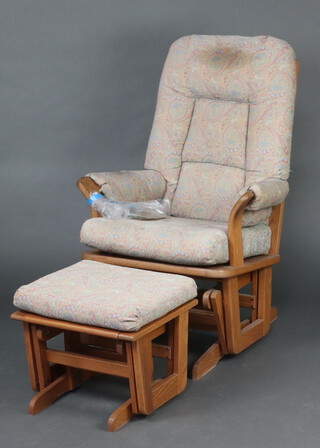 Ercol, a dark elm rocking chair together with a matching stool 