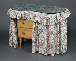 A plywood kidney shaped dressing chest fitted 2 drawers, raised on turned supports with plate glass top and floral drapes 70cm h x 91cm w x 46cm d 