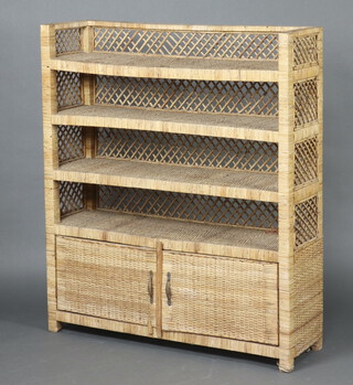 A bamboo 4 tier bookcase above cupboard enclosed by panelled doors 141cm h x 122cm w x 36cm d  