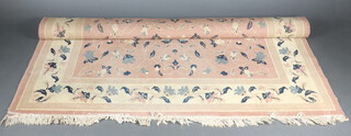 A pink and blue ground Chinese style machine made rug 287cm x 191cm (slightly stained)