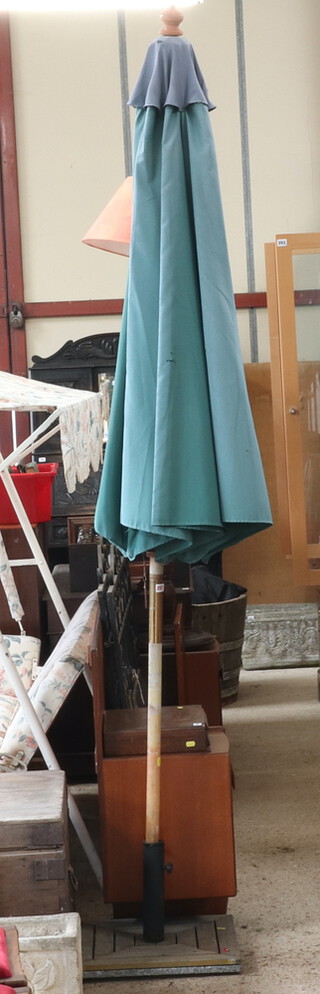 A green fabric garden parasol and stand (some small holes to parasol) 