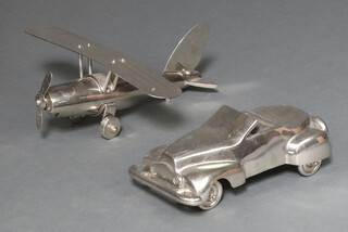 A polished metal model of an aircraft 14cm h x 33cm w x 33cm d (rear wheel missing) together with 1 other of a motor car 7cm x 28cm x 16cm 