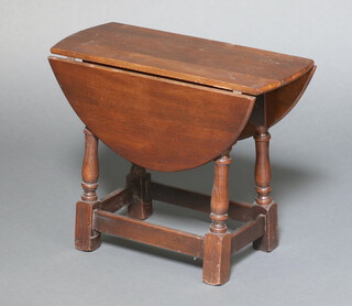 An oak oval drop flap tea table raised on turned and block supports 46cm h x 57cm x 24cm 