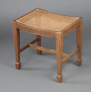 A 1930's rectangular oak dressing table stool with woven cane seat on square tapered supports, spade feet  