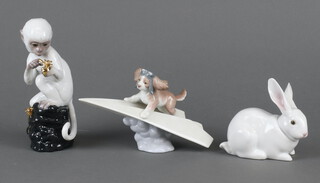 Three Lladro figures including a rabbit 5905 10cm, monkey on a rock 18cm and a dog flying on a paper plane 12cm  