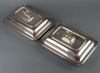 A pair of silver plated entree dishes and covers