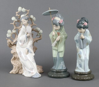 Three Lladro figures - Japanese lady holding a parasol 30cm, standing lady 26cm and a lady sitting by a tree 30cm 