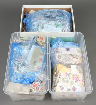 A collection of world stamps on paper contained in 2 shallow plastic boxes and a shoe box and various world stamps on paper contained in 3 boxes