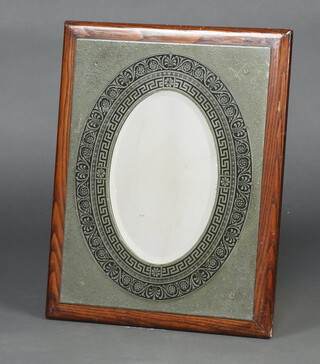 A Victorian style oval bevelled plate mirror contained in an embossed enamelled metal frame with Grecian key decoration to the outer frame 35cm x 24cm 