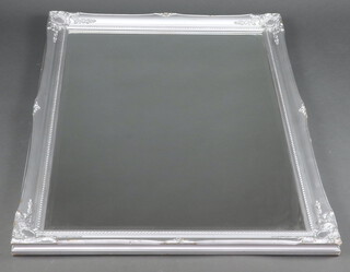 A rectangular bevelled plate mirror contained in a silvered frame 117cm x 88cm 