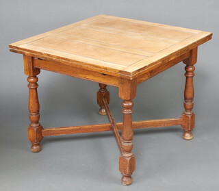 A 1930's bleached oak drawleaf dining table raised on turned supports with X framed stretcher 74cm h x 91cm w x 91cm d 