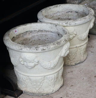 A pair of circular concrete garden urns with swag and mask decoration 34cm x 38cm 