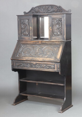 A Victorian heavily carved oak bureau with raised mirrored back carved dolphins, monogrammed P, flanked by cupboards enclosed by panelled doors, the fall front above a drawer and 2 shelves 169cm h x 94cm w x 44cm d 