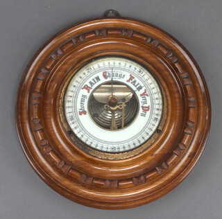 An aneroid barometer with porcelain dial contained in a circular carved wood frame 20cm 