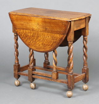 A 1930's oak oval drop flap gateleg tea table raised on a spiral turned column with casters 74cm h x 75cm w x 37cm d 