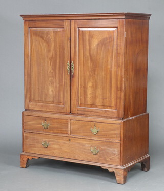 A Georgian mahogany linen press with moulded cornice, fitted 2 shelves enclosed by panelled doors, the base fitted 2 short and 1 long drawer, raised on bracket feet 175cm h x 124cm w x 60cm d 