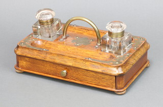 A Victorian rectangular oak ink stand with 2 pen receptacles and 2 associated cut glass ink wells (chips to the base), the base fitted a drawer 13cm h x 27cm w x 16cm d 