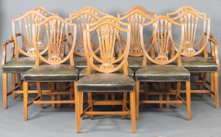 A set of 12 Hepplewhite style camel back dining chairs comprising 8 carvers 96cm h x 53cm w x 46cm d (seats 30cm x 30cm) and 4 standard chairs 96cm h x 53cm w x 45cm d (seats 28cm x 32cm), upholstered in green leather, raised on square tapered supports with H framed stretchers 