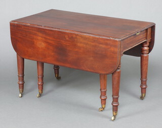 A Georgian mahogany rectangular drop flap extending dining table with 2 extra leaves, raised on ring turned supports with brass caps and casters 73cm h x 114cm w x 60cm l x 143cm l when fully extended 