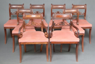 A set of 8 Georgian carved mahogany bar back dining chairs with pierced mid rails and over stuffed seats, raised on sabre supports comprising 2 carvers and 6 standard chairs  83cm h