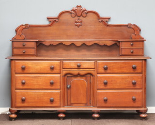 A Victorian carved mahogany chiffonier sideboard, the raised back fitted a shelf above 4 short drawers, the centre fitted a short drawer above cupboard enclosed by a panelled door, flanked by 6 long drawers with turned handles, raised on bun feet 156cm h x 195cm w x 51cm d 