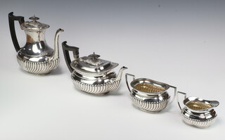 An Edwardian silver 4 piece tea and coffee set with ebony mounts and demi-fluted decoration comprising coffee pot and teapot both Sheffield 1905 and a sugar bowl and cream jug Birmingham 1902, makers Walker & Hall and James Dixon & Sons gross weight 1955 grams  