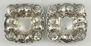 A pair of square repousse Sterling silver dishes decorated with flowers 11cm, 151 grams 