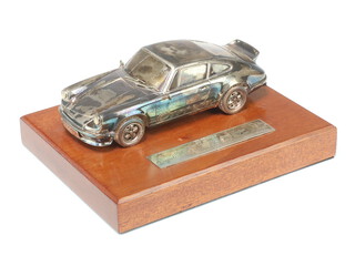 A silver model of a Porsche 911 Carrera, Asprey London 1978, 16cm, raised on a mahogany plinth with silver presentation inscription 