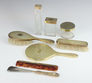 A silver gilt engine turned dressing table set comprising 3 jars, comb, shoe horn, clothes brush, hair brush and hand mirror, London 1938, weighable silver 85 grams 