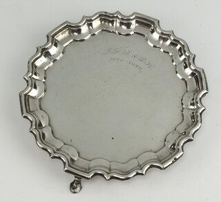 A Georgian style silver card tray with Chippendale rim, presentation inscription and hoof feet, London 1935, 16cm, 190 grams 