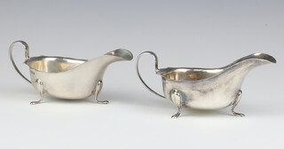 A near pair of silver sauce boats with C scroll handles on pad feet, Sheffield 1932 and 1933, 301 grams 