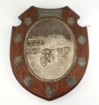 A Victorian silver plated cycling trophy Islington Cycling Club Championship Shield with repousse decoration and so engraved shields on an oak plaque 33cm 