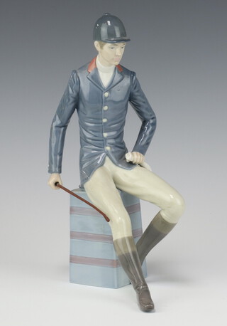 A Lladro figure of a seated horse rider on a square plinth 25cm 