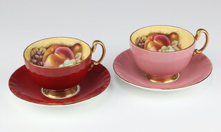 Two Aynsley tea cups and saucers decorated with fruits, pink and red 