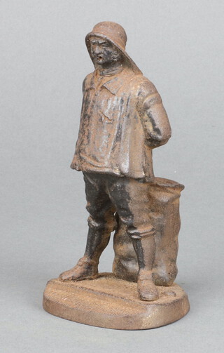 A 19th Century cast iron match striker in the form of a standing fisherman raised on a shaped base 12cm h x 6cm h x 6cm w 