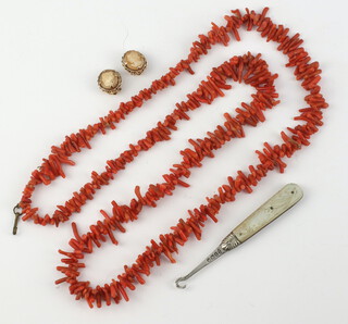 A natural coral necklace 70cm, a pair of 9ct cameo ear clips and a glove hook 