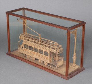 A fretwork model of a tram contained in pine and glazed case, case measures 47cm h x 81cm w x 27cm d