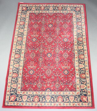 A red and green floral patterned machine made Persian style rug 196cm x 132cm 