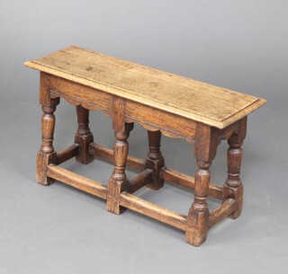 A 1930's, 17th Century style, oak double joint stool, raised on turned and block supports with H framed stretcher 41cm h x 76cm w x 24cm d 