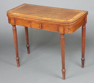 A Georgian inlaid and crossbanded mahogany D shaped tea table raised on tapered, turned and fluted supports 73cm h x 91cm w x 45cm d 