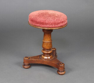 A William IV mahogany revolving adjustable piano stool upholstered in pink fabric, raised on a turned column and triform base with bun feet 48cm h x 33cm diam. 