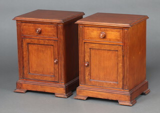 A pair of Victorian style crossbanded mahogany bedside cabinets with fluted columns to the sides, each fitted a drawer above cupboard, raised on ogee bracket feet 70cm h x 51cm w x 44cm d 