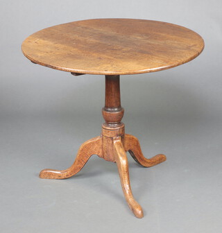 An 18th Century circular oak snap top tea table raised on pillar and tripod base 69cm x 80cm 