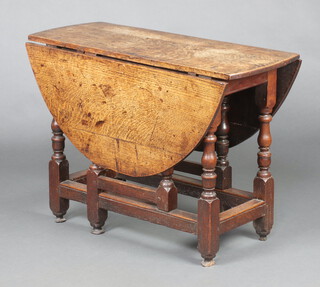 An 18th Century oak oval drop flap gateleg dining table raised on turned supports 70cm h x 99cm w x 40cm, (previously fitted a drawer) 