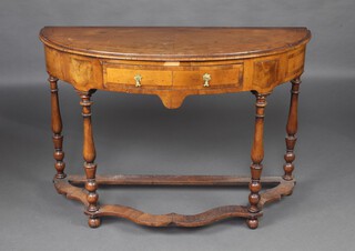 A Queen Anne style crossbanded walnut bow front side table fitted a frieze drawer, raised on turned supports with wavy shaped stretcher 76cm h x 113cm w x 46cm d 