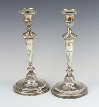 A pair of George III silver tapered candlesticks with ribbed decoration and engraved armorials, Sheffield 1800, maker John Green, Roberts, Mosley and Co, 32cm 