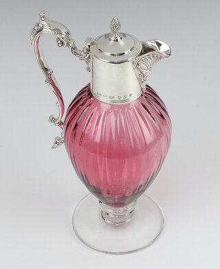 A Victorian style cranberry and clear glass ewer with silver mounts having a mask scroll spout, pineapple finial and S scroll handle, London 2000, maker WW 28cm 