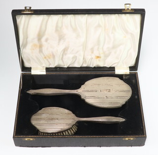 A sterling silver hand mirror and hair brush, cased 