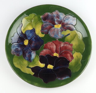 A Moorcroft plate decorated "Clematis", designed by Walter Moorcroft, signature and impressed mark 26cm